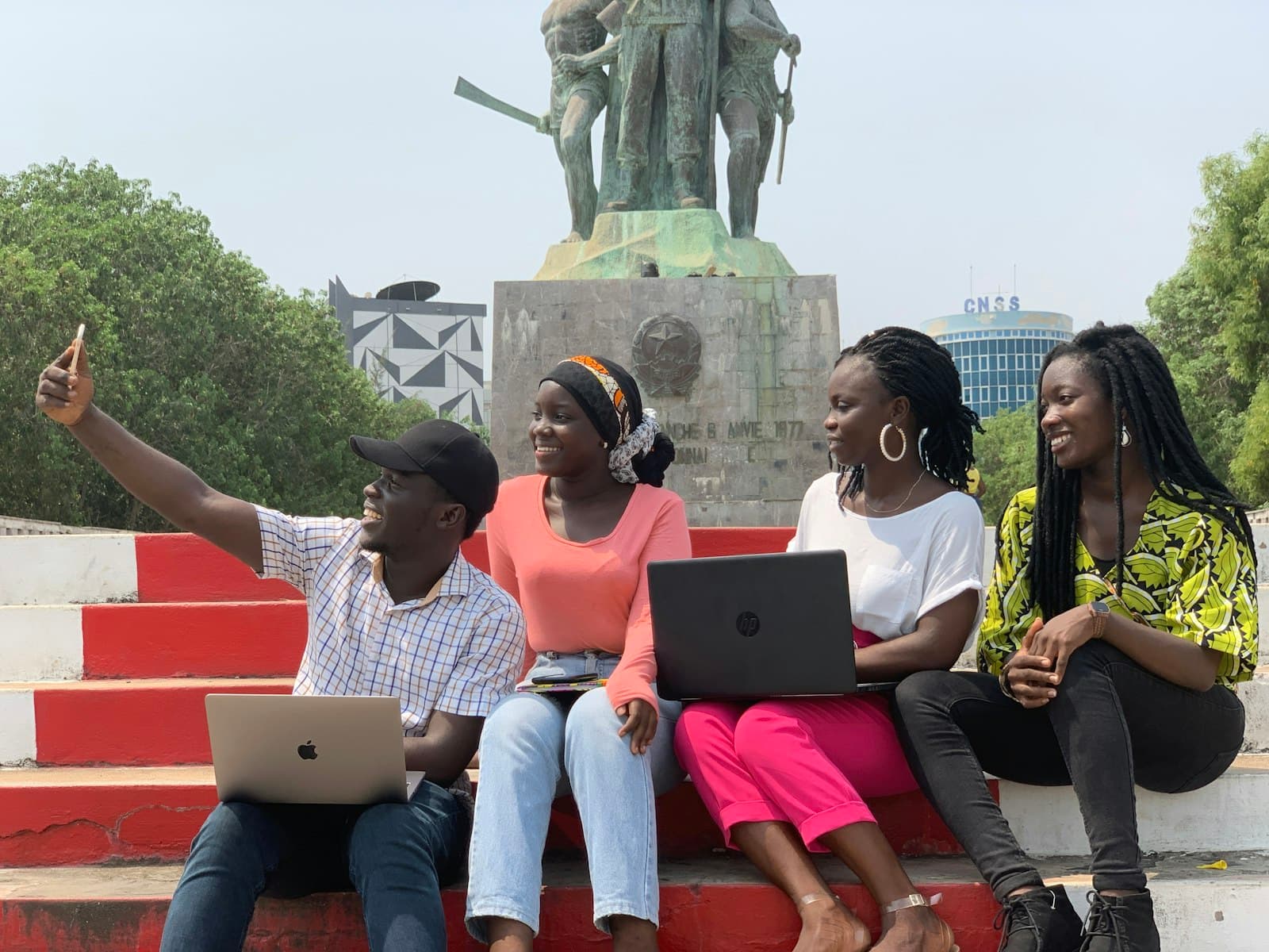 Young people learning together on their laptops outdoors