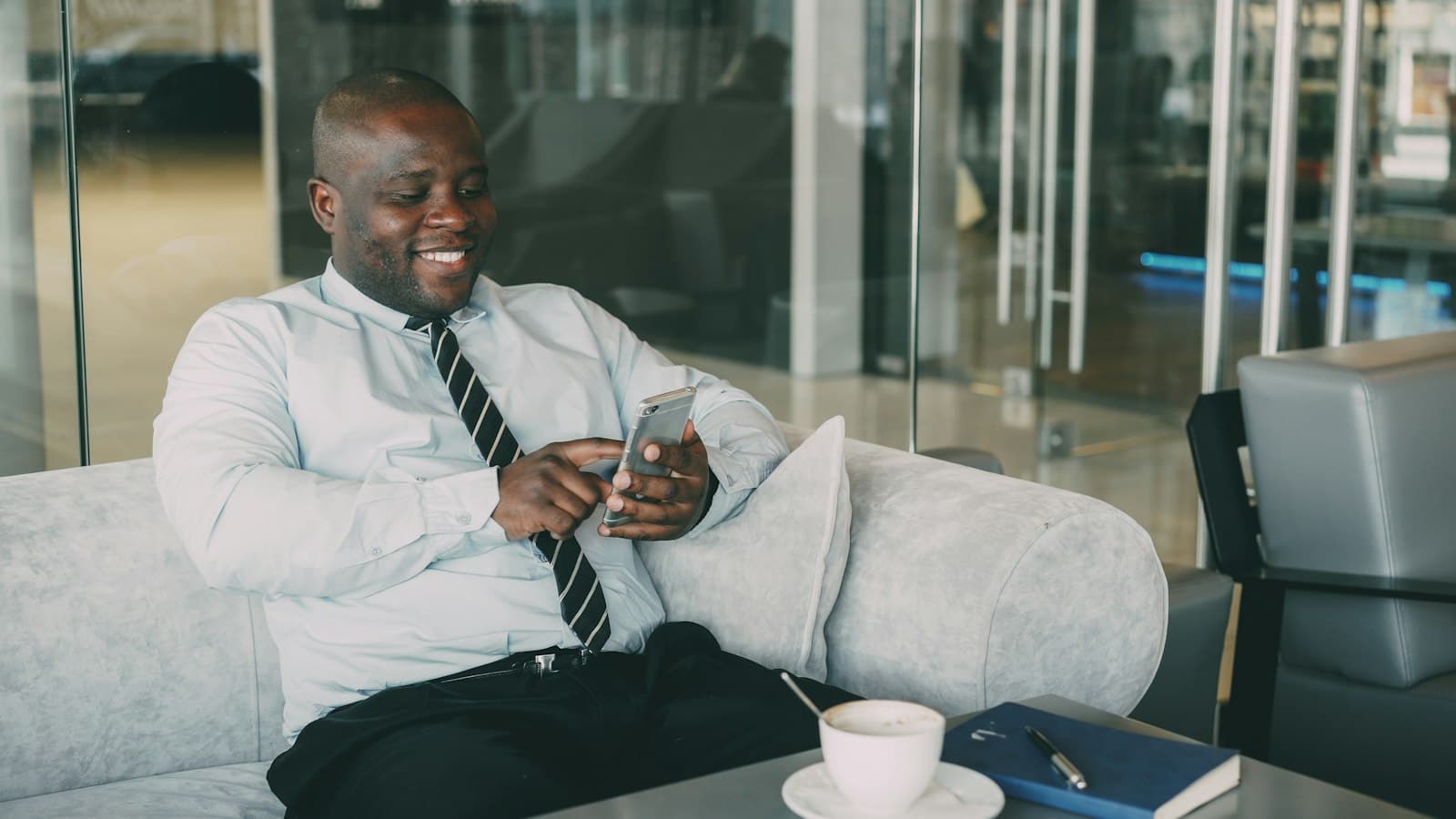 A smiling salesman reading a message on his phone