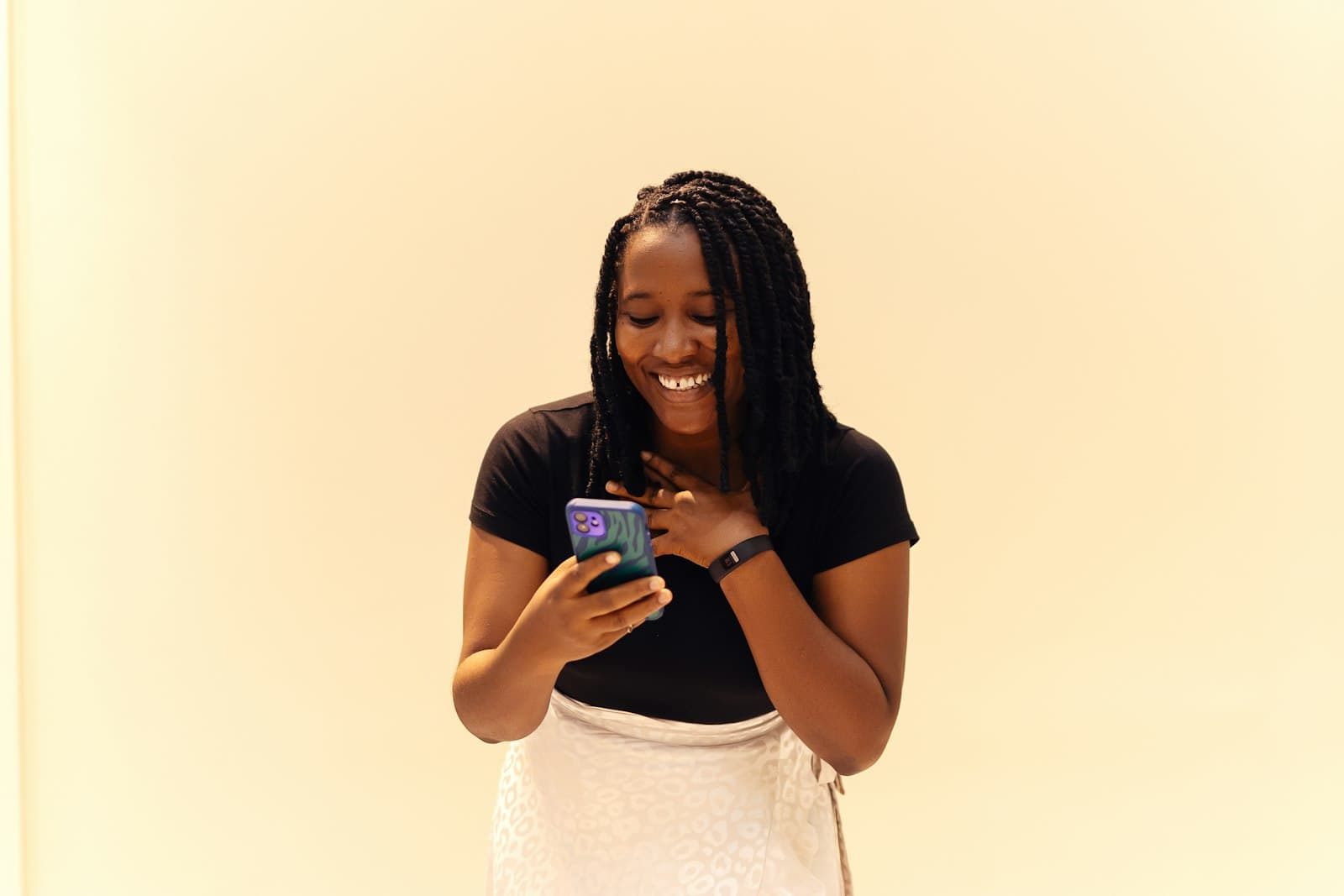 A young woman smiling at her phone