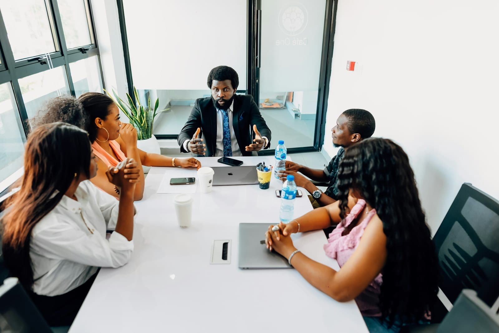 A team meeting around a table with laptops