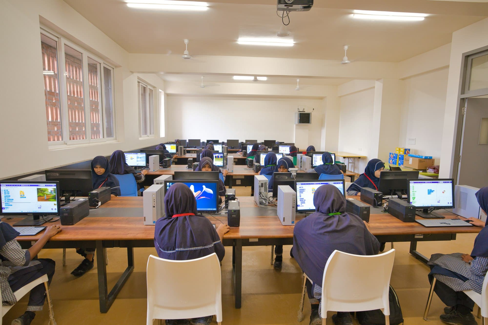 A modern, fully equipped school computer lab with students at work