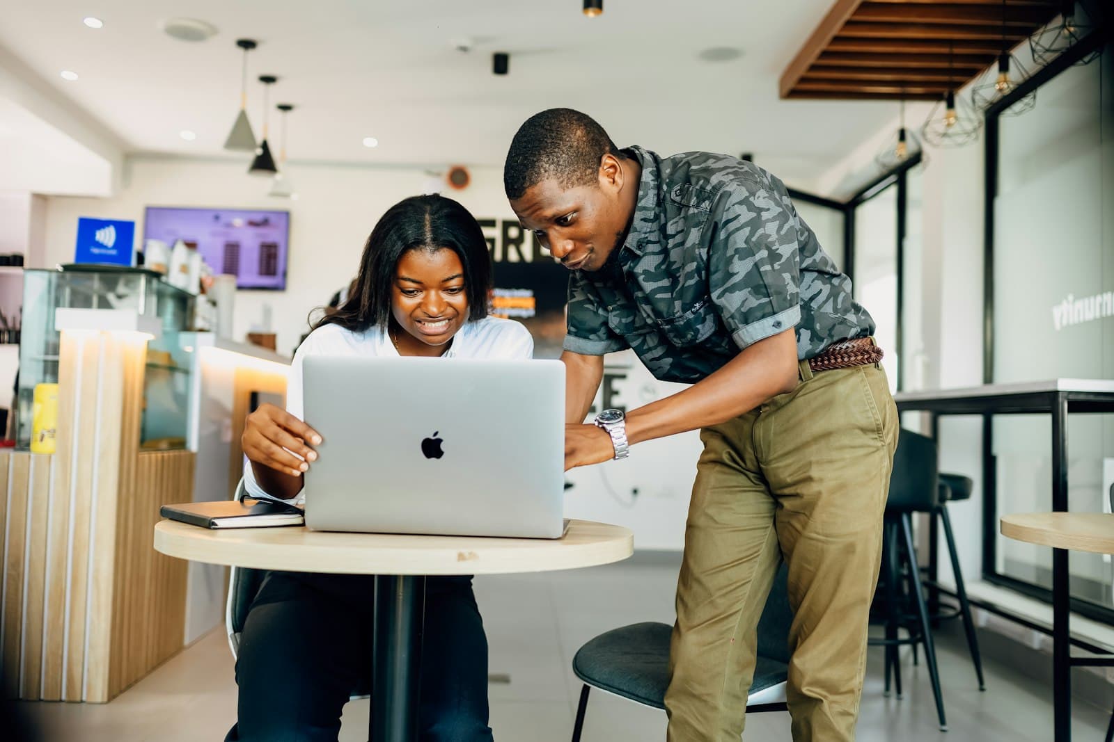 Two young people working through a task on a laptop together